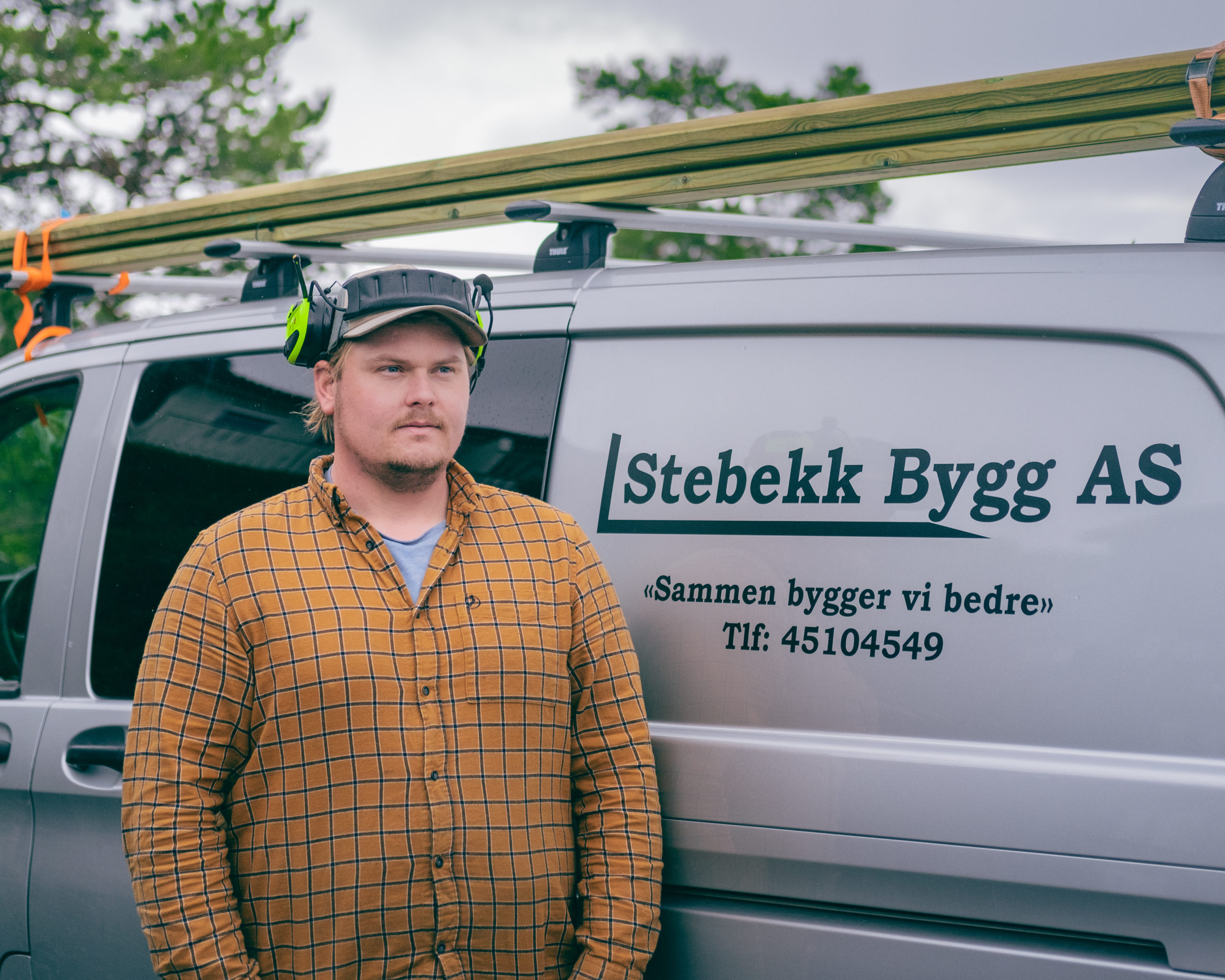 Tømrer Fredrik Stebekk foran firmabilen til Stabekk Bygg AS