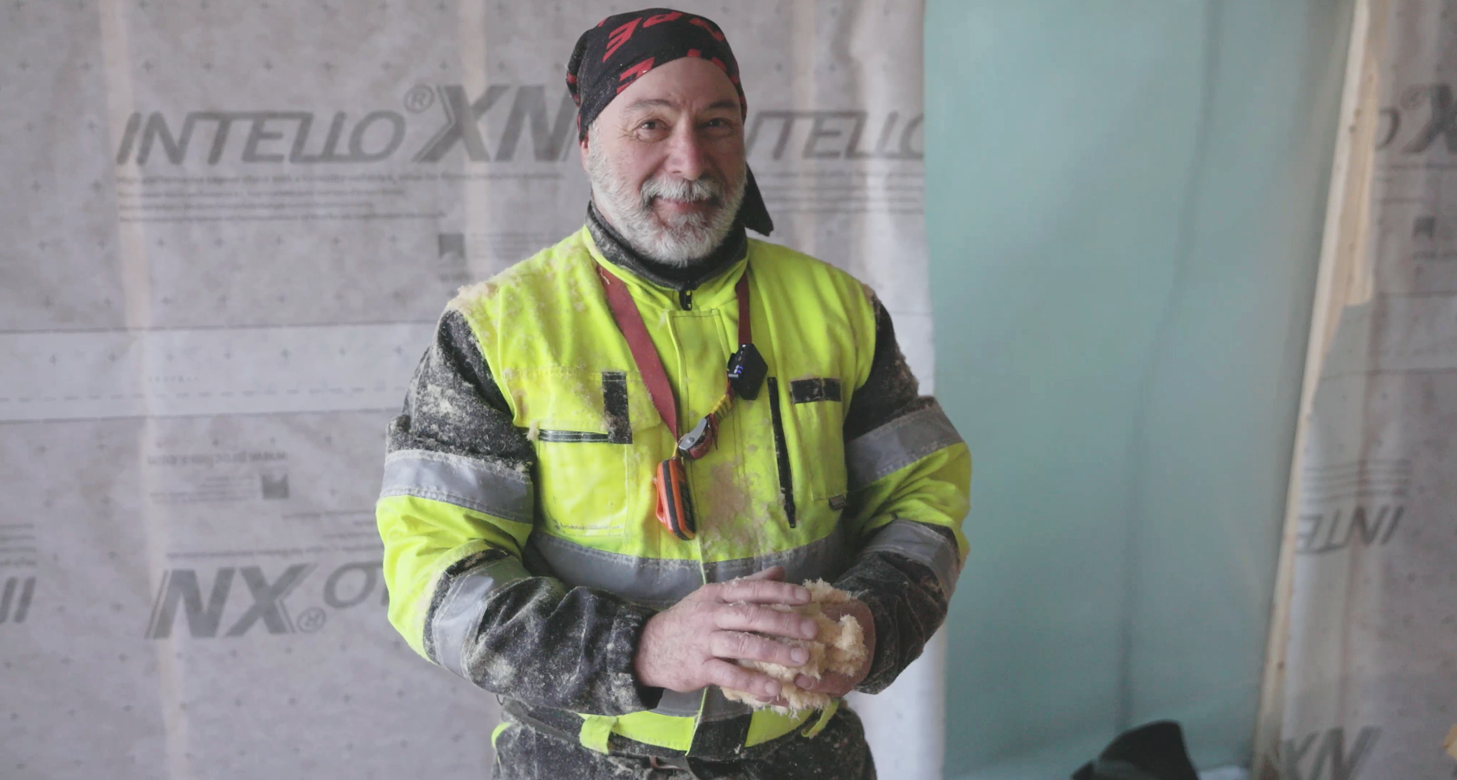 Anpe Oy:n työntekijä pitelee puukuitueristettä käsissään